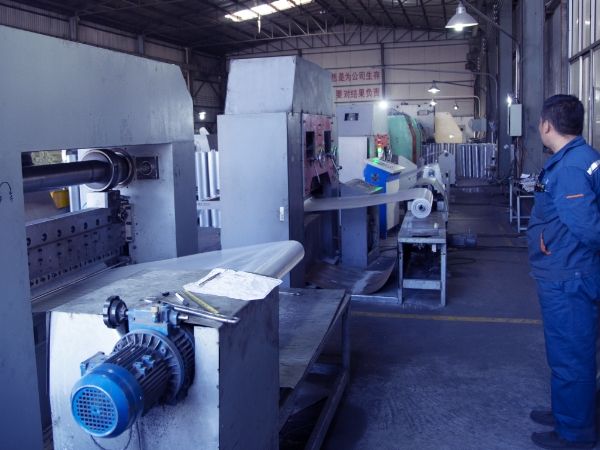 A worker is operating the micro expanded metal production machine.